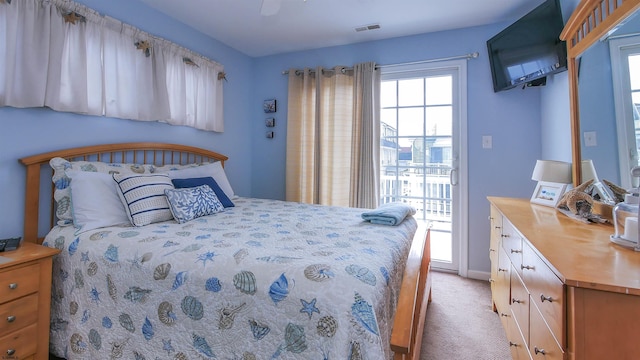 bedroom featuring baseboards, visible vents, a ceiling fan, light colored carpet, and access to exterior