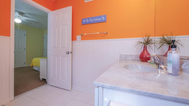 bathroom with a wainscoted wall, ceiling fan, vanity, and tile patterned floors