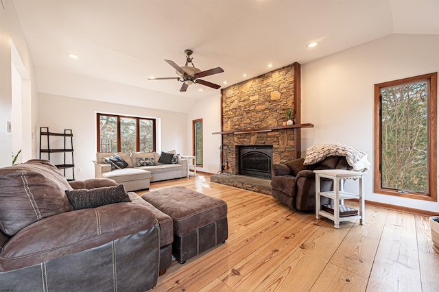 living area featuring lofted ceiling, a stone fireplace, recessed lighting, a ceiling fan, and light wood finished floors