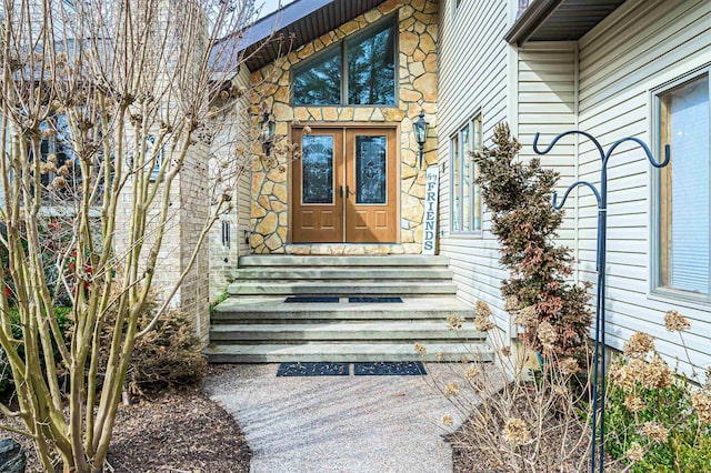 view of exterior entry with stone siding and french doors