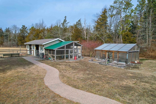 view of community featuring a yard, an outdoor structure, and an exterior structure