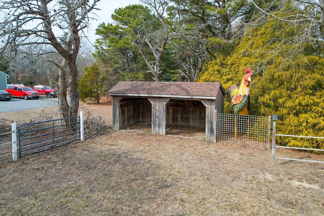 view of outdoor structure featuring fence and an outdoor structure