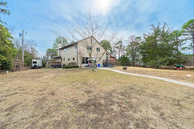 view of front of home with a chimney and a front lawn