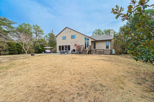 back of house with a patio area, a chimney, and a lawn