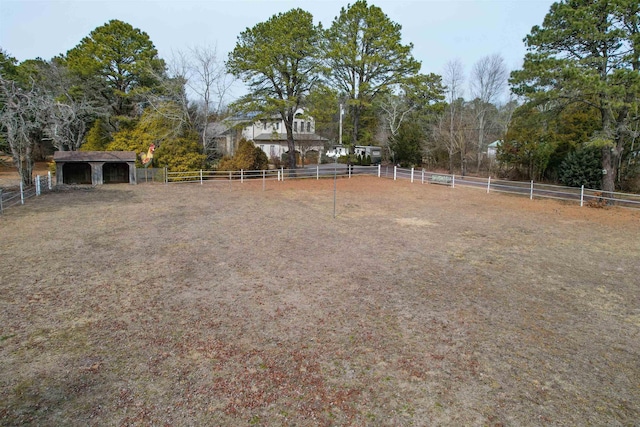 view of yard with an enclosed area, an outdoor structure, and fence