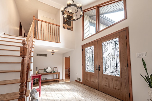 entryway featuring a chandelier, brick floor, visible vents, and stairway