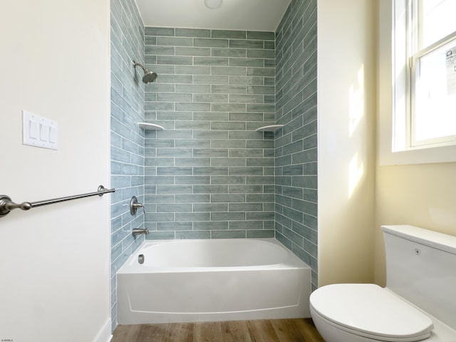 bathroom with toilet, wood finished floors, and shower / bathing tub combination