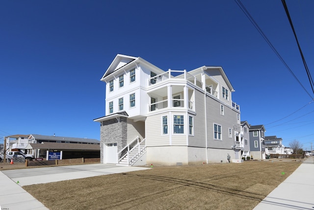 exterior space featuring concrete driveway, an attached garage, and a balcony