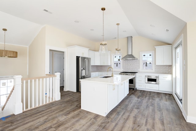 kitchen with visible vents, wall chimney exhaust hood, high quality appliances, vaulted ceiling, and a sink