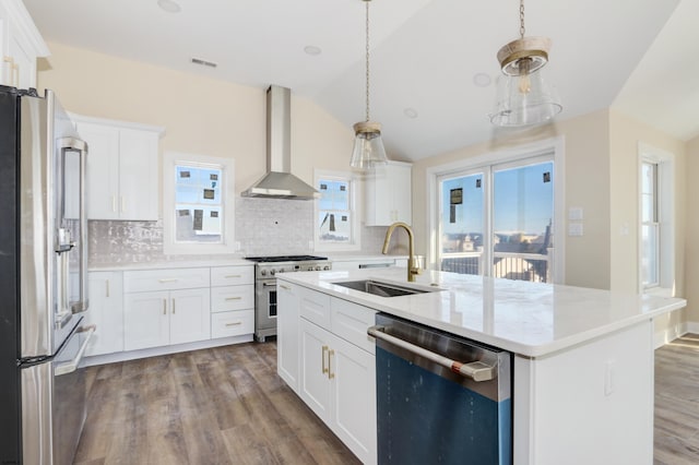 kitchen with light countertops, dark wood-type flooring, a sink, wall chimney range hood, and high quality appliances