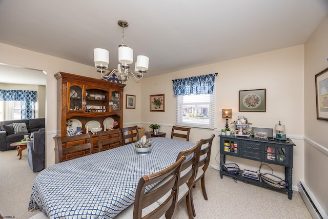 dining area with a chandelier, baseboards, light carpet, and baseboard heating