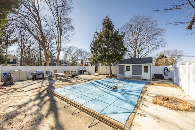 view of pool with a fenced in pool, an outbuilding, a patio, an exterior structure, and a fenced backyard