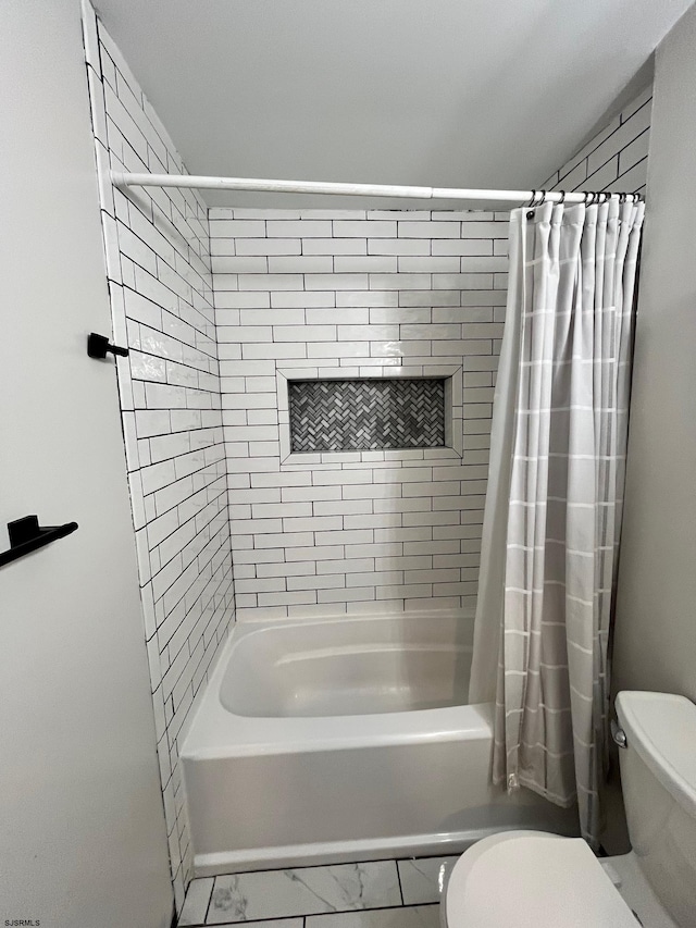 bathroom featuring marble finish floor, shower / bath combination with curtain, and toilet