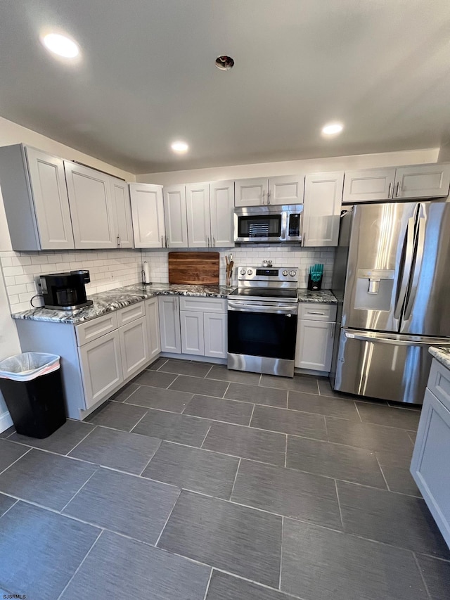 kitchen featuring appliances with stainless steel finishes, recessed lighting, decorative backsplash, and light stone countertops