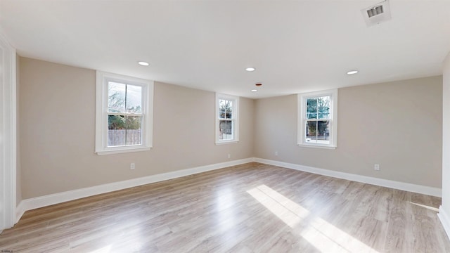 spare room featuring light wood-type flooring, baseboards, visible vents, and recessed lighting