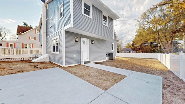 rear view of house with a deck, central AC unit, a patio area, and a fenced backyard