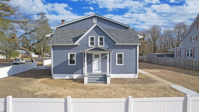 bungalow with a fenced front yard and a shingled roof