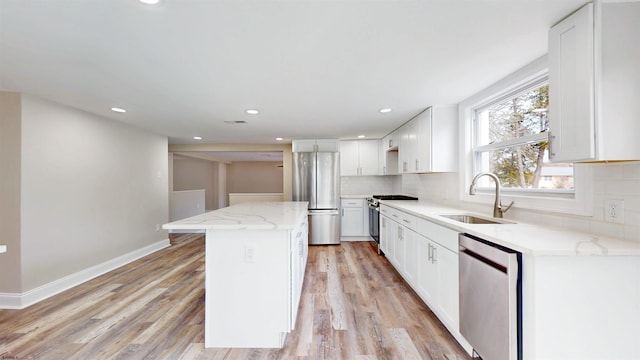 kitchen featuring backsplash, stainless steel appliances, a sink, and a center island