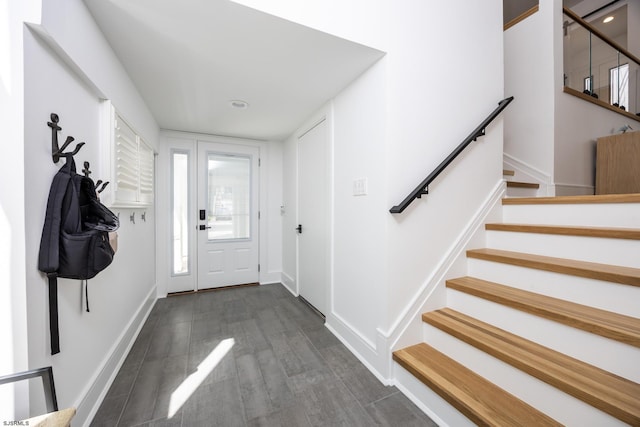 entrance foyer with stairs, baseboards, and dark wood-style flooring