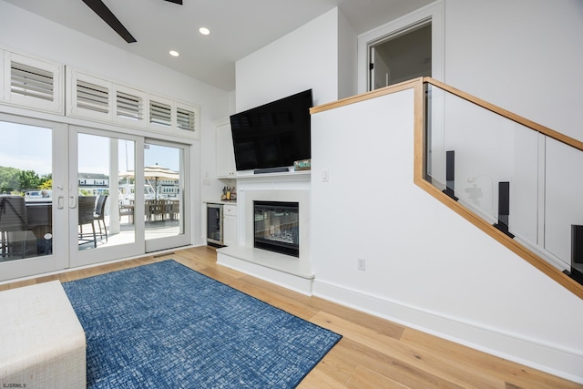 living room featuring ceiling fan, recessed lighting, wood finished floors, baseboards, and a glass covered fireplace