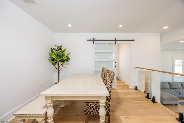 dining area featuring recessed lighting, light wood-style flooring, baseboards, and a barn door