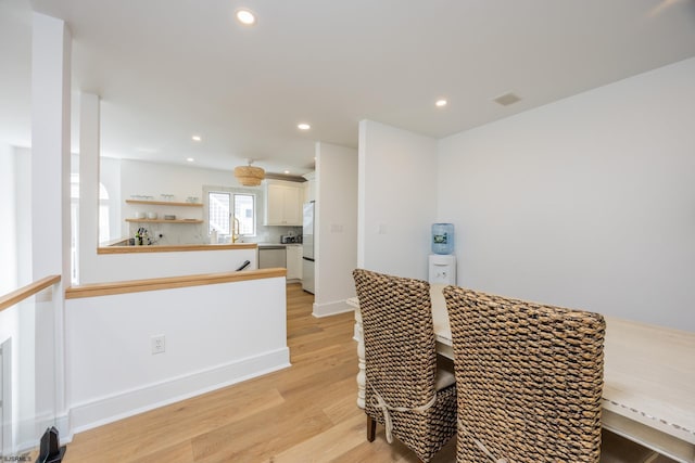 dining space with baseboards, light wood-style flooring, and recessed lighting