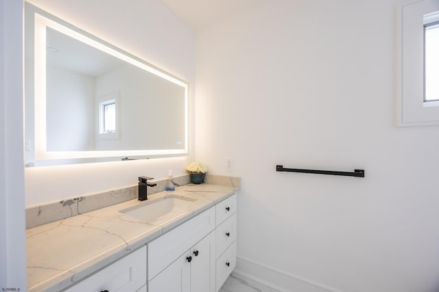 bathroom with marble finish floor, baseboards, and vanity