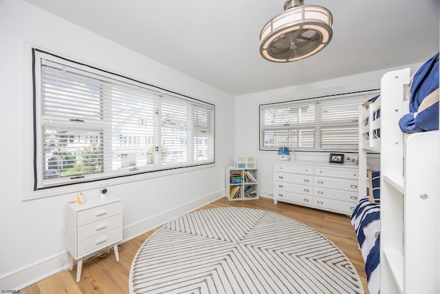 bedroom featuring light wood finished floors and baseboards