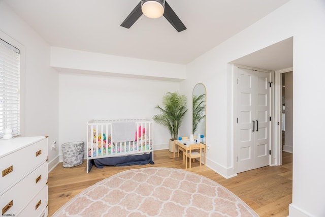 bedroom featuring a ceiling fan, baseboards, and light wood finished floors