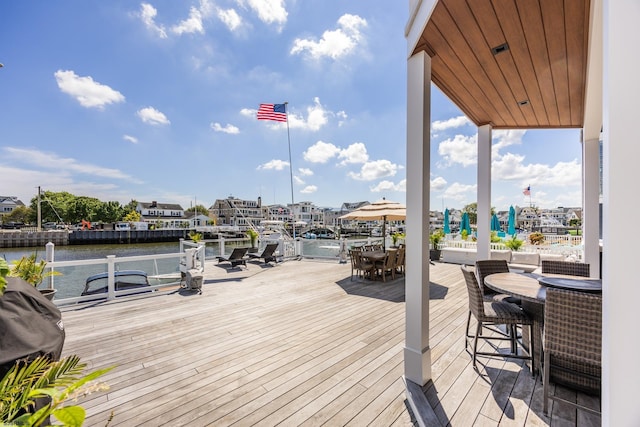 deck featuring outdoor dining space and a water view