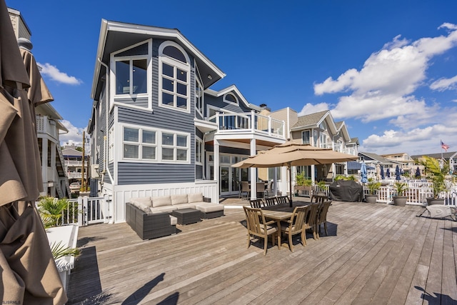 back of house featuring outdoor dining space, a residential view, a balcony, and an outdoor living space