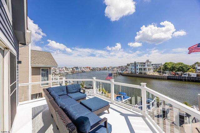 balcony featuring a water view and an outdoor living space