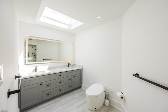 full bath with double vanity, a sink, toilet, and baseboards