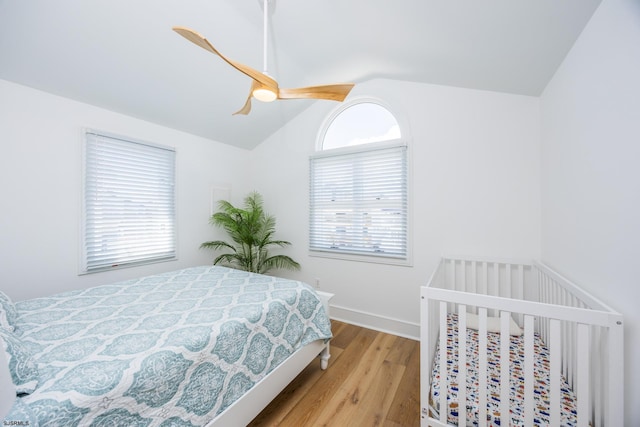 bedroom featuring vaulted ceiling, wood finished floors, a ceiling fan, and baseboards