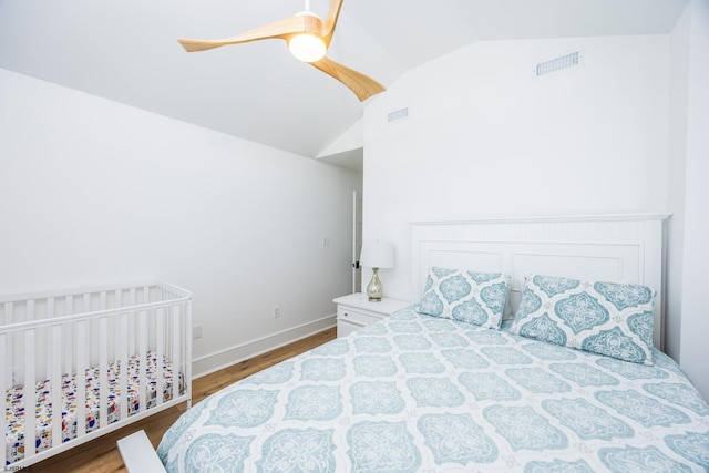 bedroom with lofted ceiling, visible vents, ceiling fan, and wood finished floors