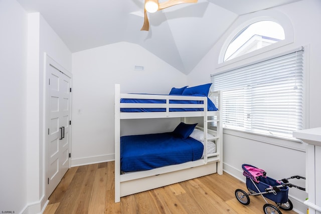 bedroom with lofted ceiling, baseboards, a ceiling fan, and wood finished floors