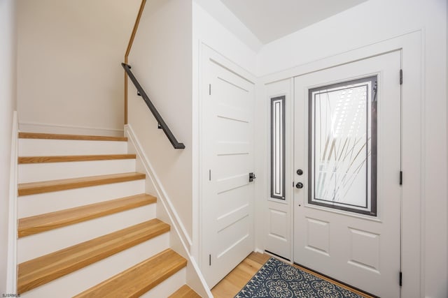 foyer entrance with light wood finished floors and stairs