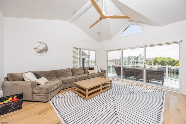 living area featuring light wood-style floors, ceiling fan, visible vents, and high vaulted ceiling