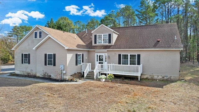 view of front of house with roof with shingles and a wooden deck