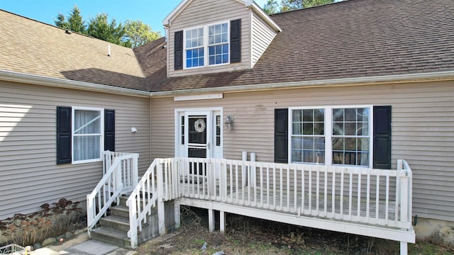 entrance to property featuring roof with shingles