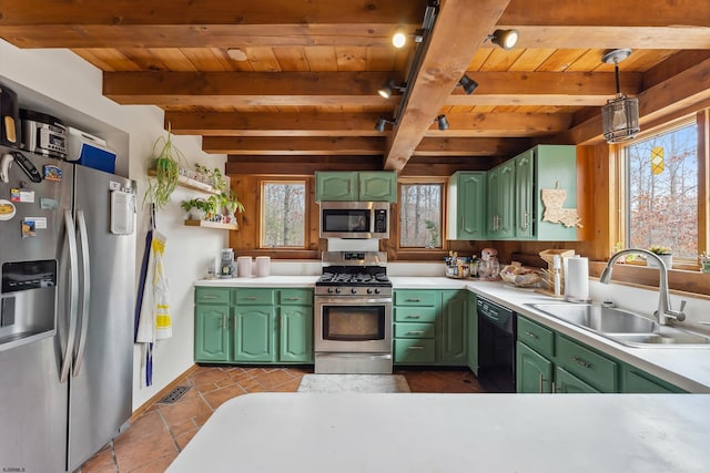 kitchen with green cabinets, stainless steel appliances, a sink, and light countertops