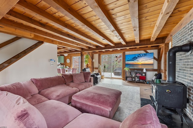 living area with wood finished floors, wood ceiling, stairs, beam ceiling, and a wood stove