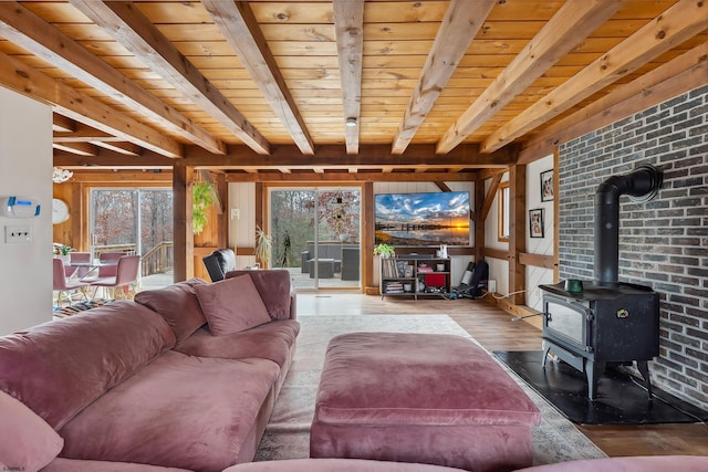 living room featuring wood ceiling, a wood stove, beamed ceiling, and wood finished floors