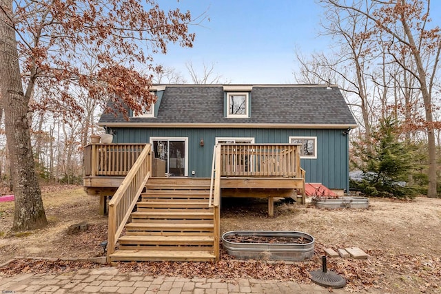 back of house with a deck, a shingled roof, and stairs