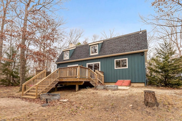 back of house featuring a deck, stairway, and roof with shingles