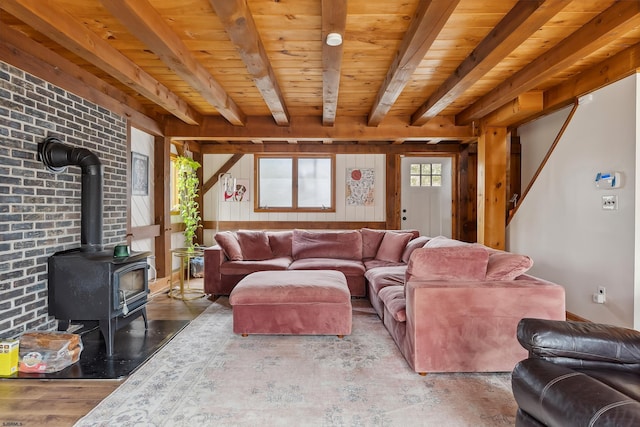 living room featuring wood ceiling, beamed ceiling, wood finished floors, and a wood stove