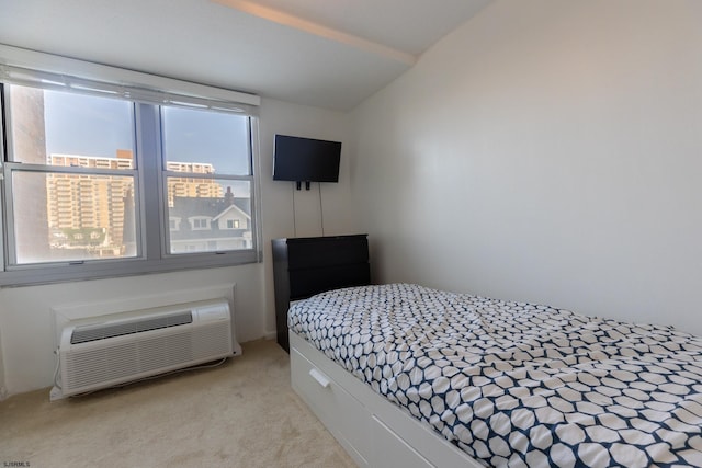 bedroom featuring lofted ceiling, a wall mounted AC, and light colored carpet