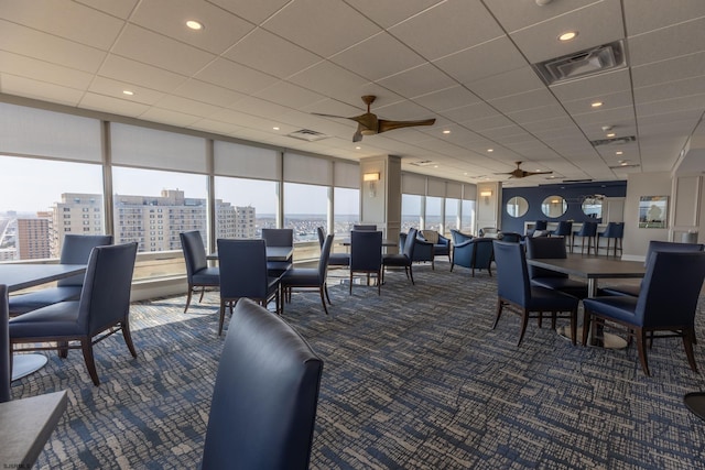 carpeted dining area with a view of city, visible vents, and a ceiling fan