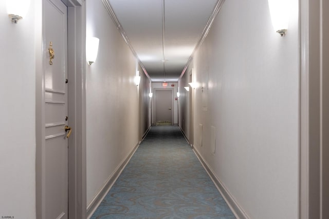 corridor featuring carpet flooring, crown molding, and baseboards