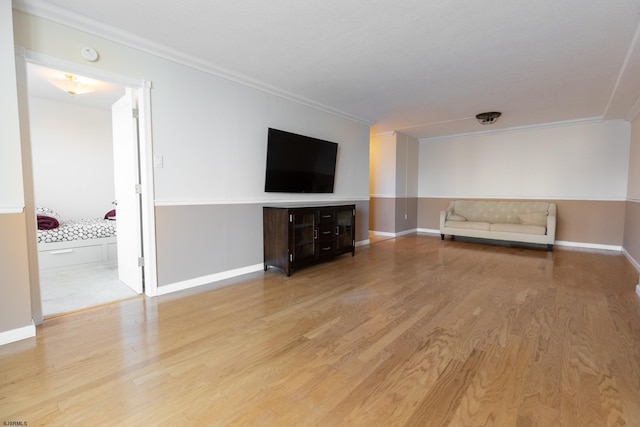 unfurnished living room with light wood-style floors, baseboards, and ornamental molding